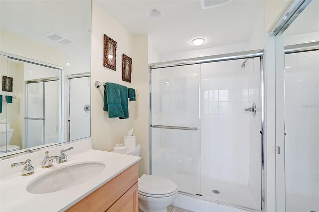 bathroom featuring vanity, toilet, and an enclosed shower