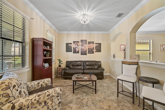 living room featuring visible vents, arched walkways, baseboards, and ornamental molding