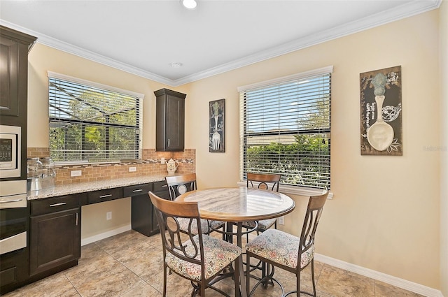 dining space with a wealth of natural light, baseboards, and crown molding