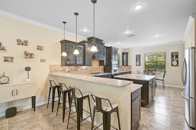 kitchen featuring visible vents, appliances with stainless steel finishes, a kitchen bar, crown molding, and a center island