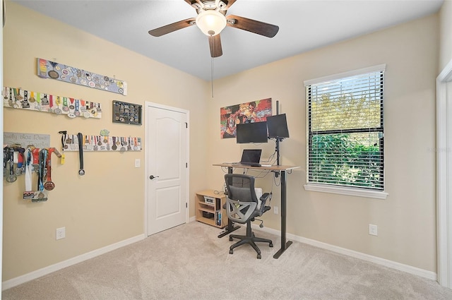 carpeted office space with baseboards and ceiling fan