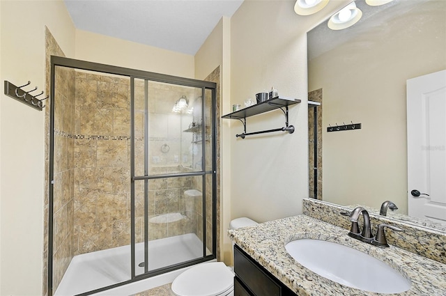 full bath with vanity, a shower stall, and toilet