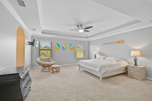 bedroom featuring a tray ceiling, ornamental molding, visible vents, and light carpet