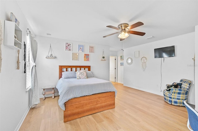 bedroom featuring a ceiling fan, visible vents, baseboards, and light wood-type flooring