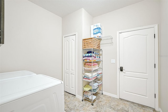 clothes washing area featuring laundry area, washing machine and dryer, and baseboards