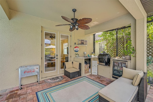 view of patio with exterior kitchen, ceiling fan, wine cooler, french doors, and a grill