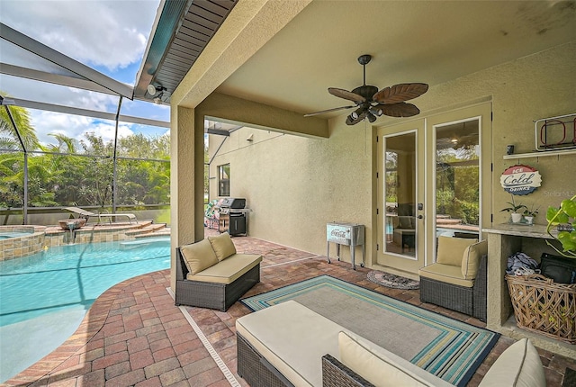 view of patio / terrace with a lanai, a pool with connected hot tub, and ceiling fan