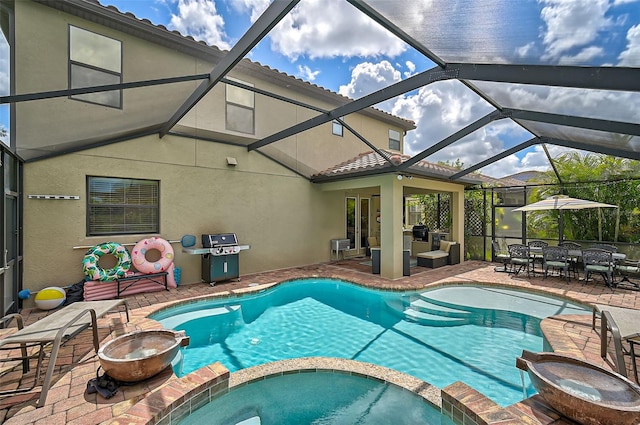 view of swimming pool featuring a patio, a pool with connected hot tub, a fire pit, grilling area, and a lanai