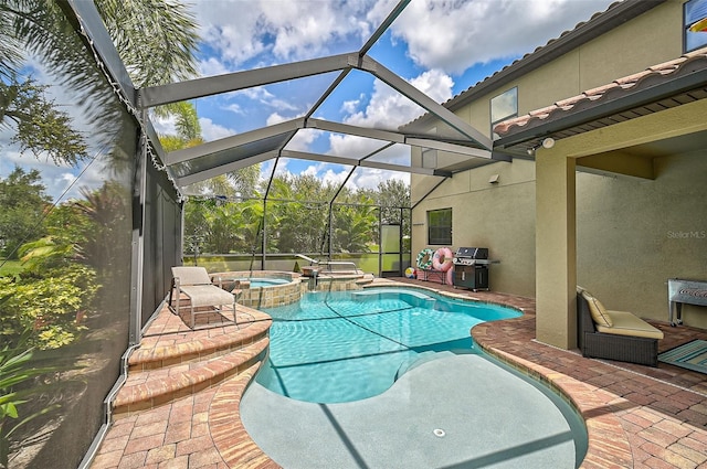 view of pool with a patio, a lanai, a pool with connected hot tub, and grilling area