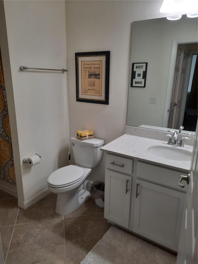 bathroom with tile patterned flooring, vanity, and toilet