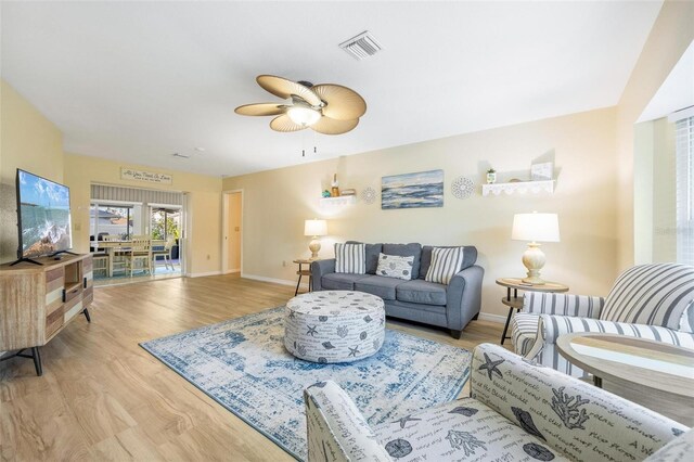 living room with ceiling fan and light hardwood / wood-style floors