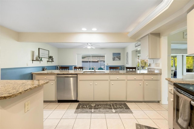 kitchen with light tile patterned floors, sink, cream cabinets, ceiling fan, and appliances with stainless steel finishes