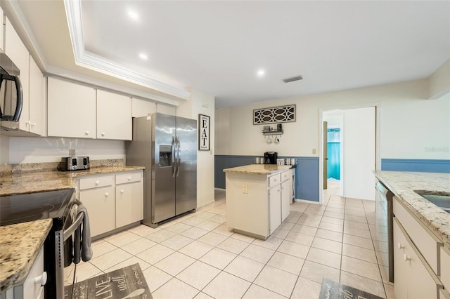 kitchen with light stone counters, a kitchen island, stainless steel appliances, and light tile patterned flooring