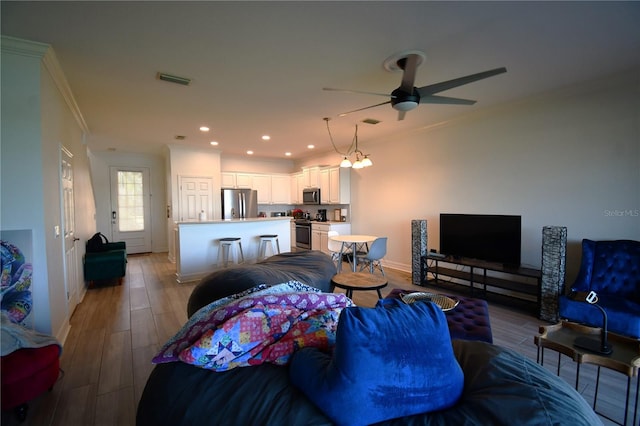 living room featuring ornamental molding, hardwood / wood-style floors, and ceiling fan