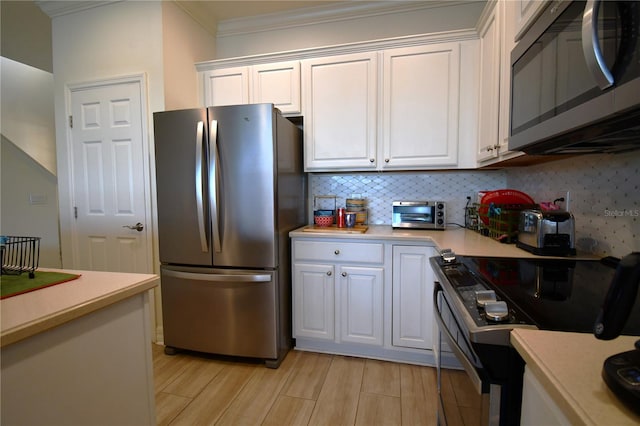 kitchen featuring light wood-type flooring, appliances with stainless steel finishes, and white cabinets