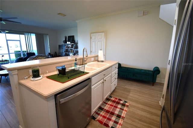 kitchen with white cabinets, light hardwood / wood-style flooring, stainless steel appliances, sink, and a center island with sink