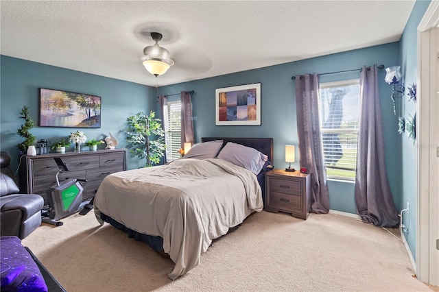 bedroom with ceiling fan, light carpet, and multiple windows