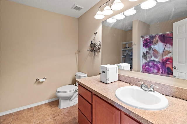 bathroom with toilet, vanity, walk in shower, and tile patterned floors