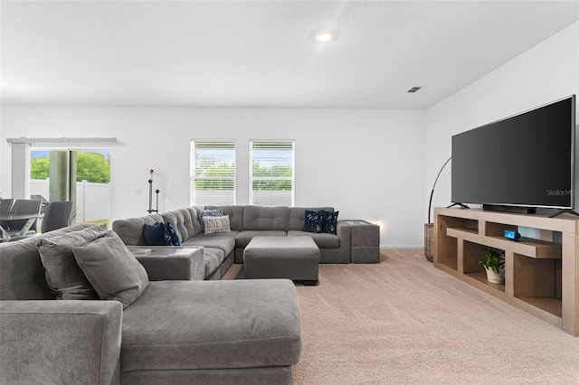 living room with light carpet, a healthy amount of sunlight, and visible vents