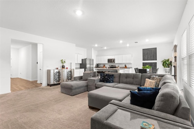 living area featuring recessed lighting and light colored carpet