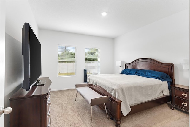 bedroom featuring light colored carpet and baseboards