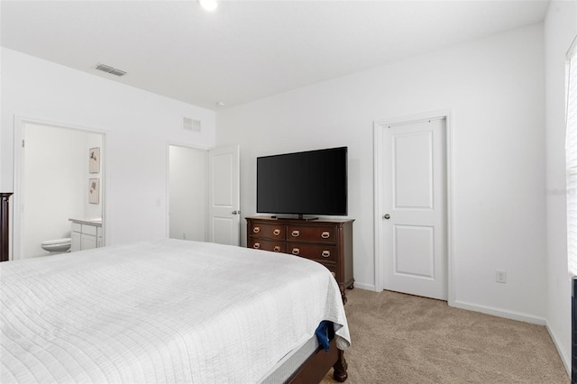 bedroom with light carpet, baseboards, visible vents, and connected bathroom