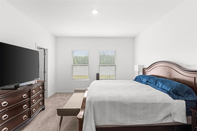 bedroom featuring baseboards and light colored carpet