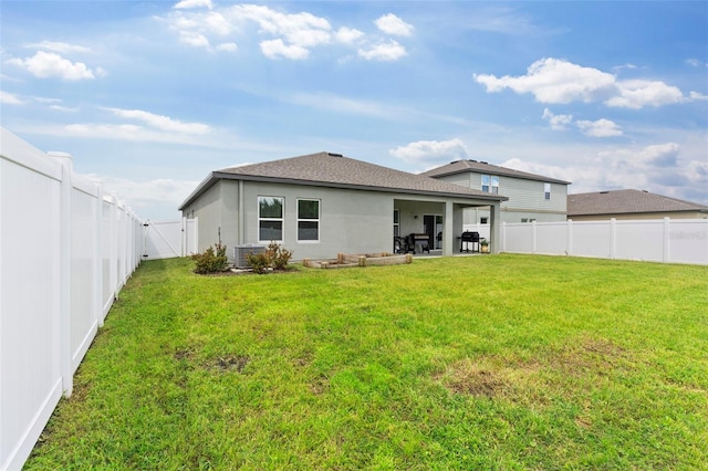 back of house with a fenced backyard, a patio, a lawn, and stucco siding