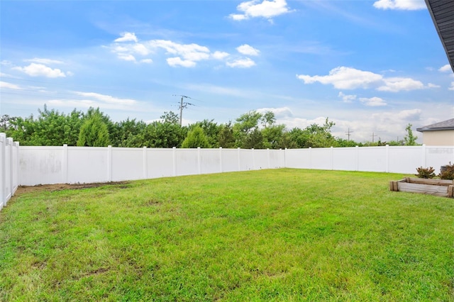 view of yard with a fenced backyard and a garden