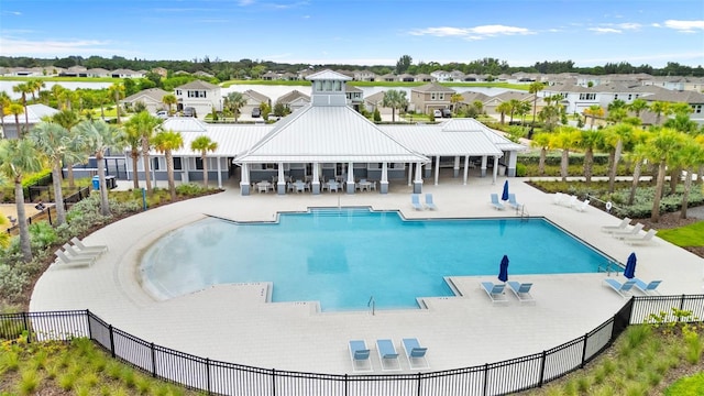 community pool featuring a patio area, a residential view, and fence