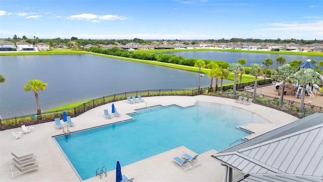 pool featuring a water view, fence, and a patio