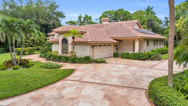 mediterranean / spanish-style house featuring a garage and a front lawn