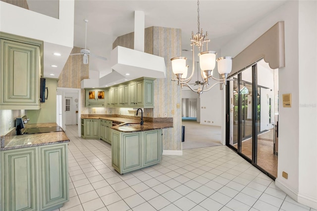 kitchen featuring kitchen peninsula, light carpet, sink, black appliances, and green cabinetry