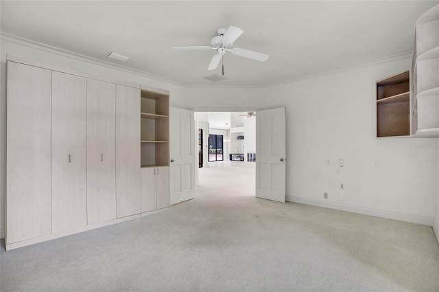 unfurnished bedroom featuring ornamental molding, light colored carpet, and ceiling fan