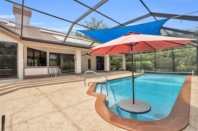 view of swimming pool with a patio area, ceiling fan, and glass enclosure