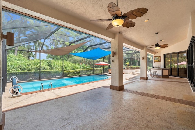 view of pool featuring a patio, ceiling fan, and glass enclosure