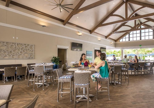 dining space with dark wood-type flooring, beam ceiling, and high vaulted ceiling