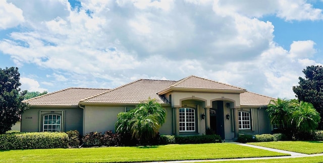 mediterranean / spanish home featuring a front yard