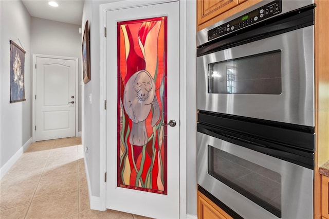 interior space with stainless steel double oven, brown cabinets, baseboards, and recessed lighting