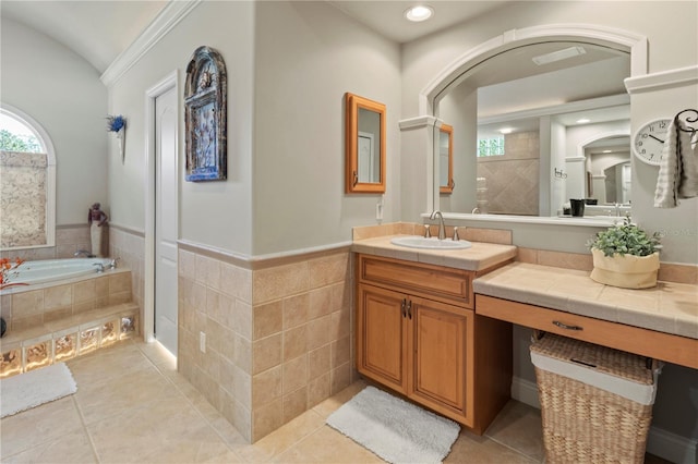 full bathroom with a wainscoted wall, a garden tub, tile walls, vanity, and tile patterned flooring