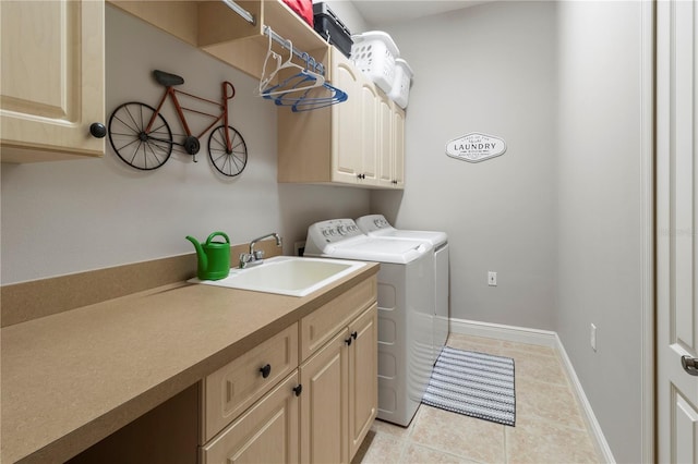 laundry area with light tile patterned floors, a sink, baseboards, independent washer and dryer, and cabinet space