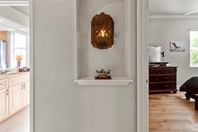 hall with crown molding and a sink