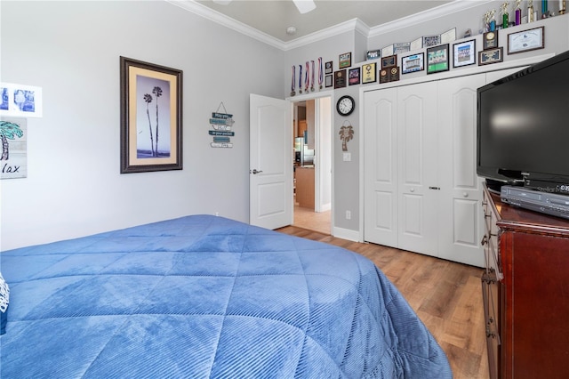 bedroom featuring ceiling fan, a closet, crown molding, and wood finished floors