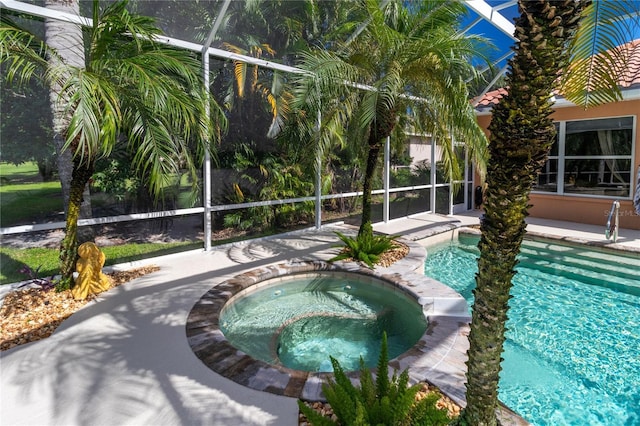 outdoor pool with an in ground hot tub, a patio, and glass enclosure