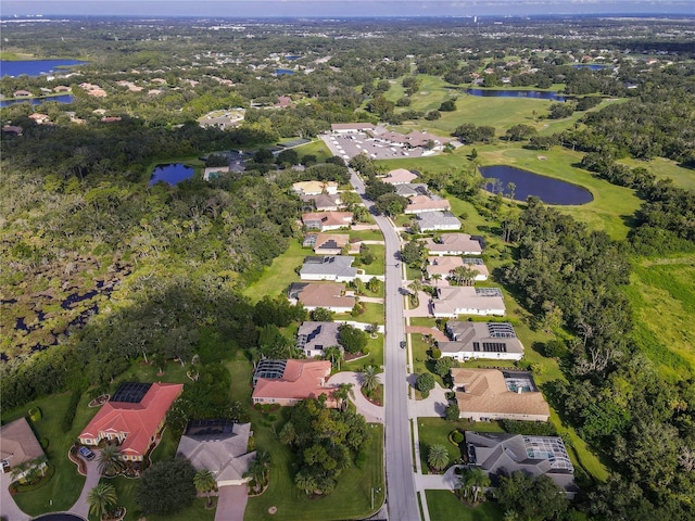 drone / aerial view featuring a water view, view of golf course, and a residential view