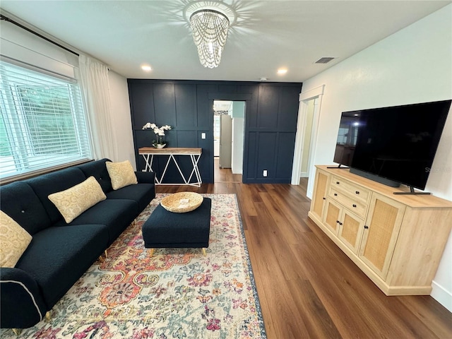 living room with dark hardwood / wood-style flooring and a chandelier