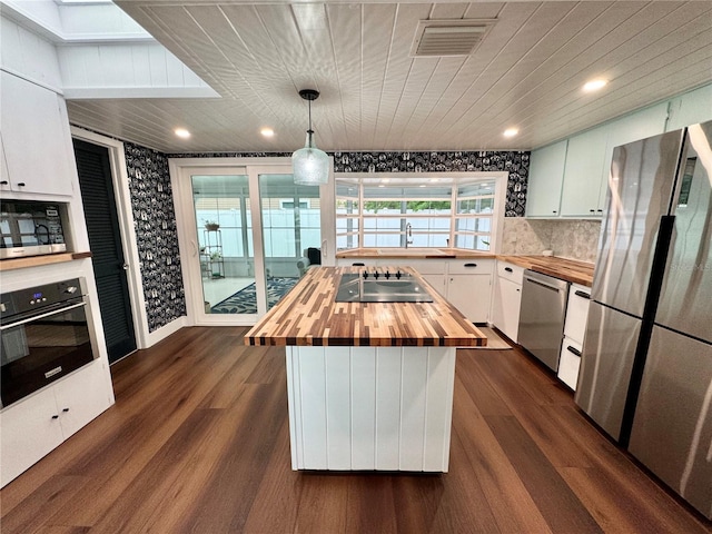 kitchen with white cabinets, wood counters, stainless steel appliances, dark hardwood / wood-style flooring, and a kitchen island