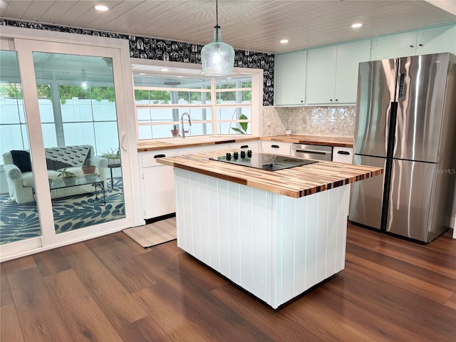 kitchen featuring a kitchen island, stainless steel fridge, pendant lighting, dark wood-type flooring, and butcher block counters