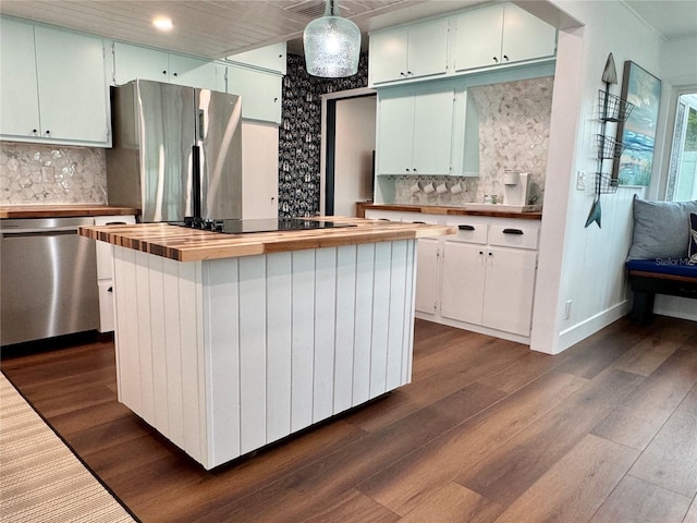 kitchen featuring decorative light fixtures, stainless steel appliances, white cabinetry, dark wood-type flooring, and a kitchen island