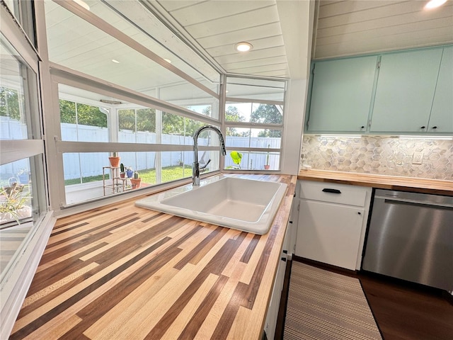 kitchen with backsplash, dishwasher, plenty of natural light, and vaulted ceiling with beams